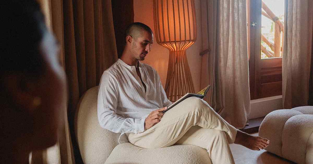 A guest reading in a warm, quietly designed interior